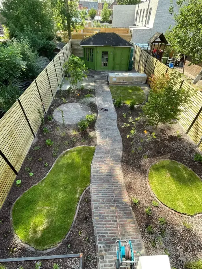 Vakkundige tuinaanleg met terras, zwemvijver en beplanting gerealiseerd door Tuinen Geoffrey Debergh in regio Ieper